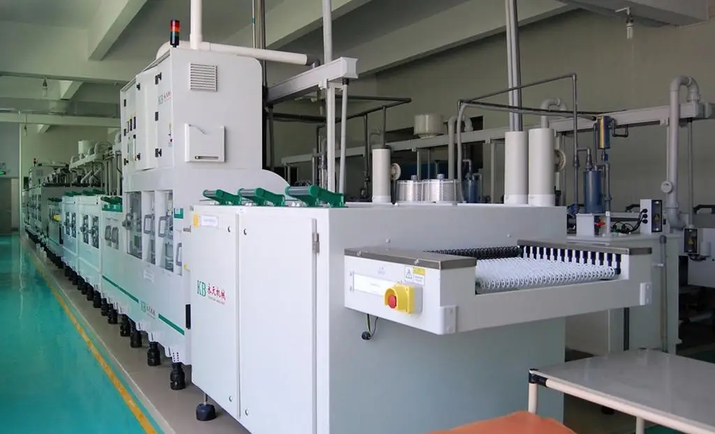Long shot of an advanced automated PCB processing line with multiple modular machines, conveyors, and handling systems in a clean industrial facility.