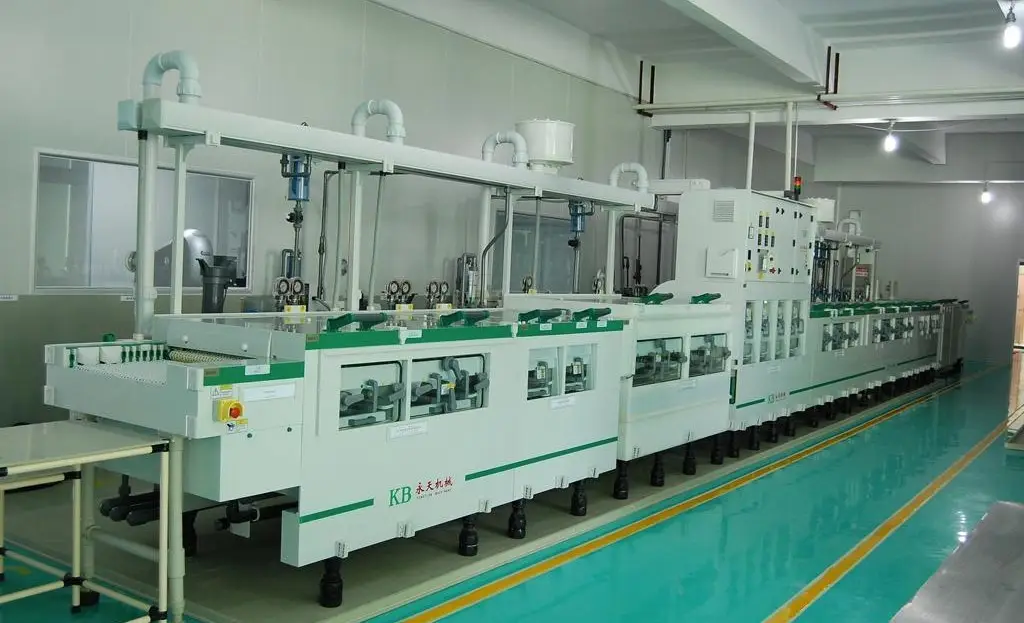 Full view of a long white and green automatic wet processing line, likely for PCB plating or etching, in a clean manufacturing facility.